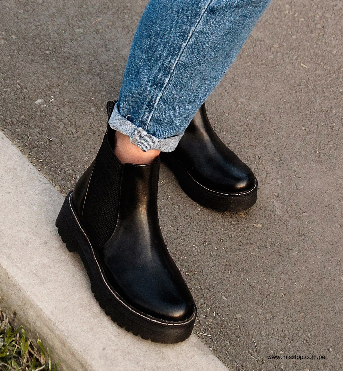 botines misstop chelsea plataforma negro modelado por los pies de una mujer con jeans azules